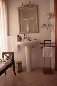 uma casa de banho com um lavatório branco e um espelho. em Hostal Antigua Morellana em Valência