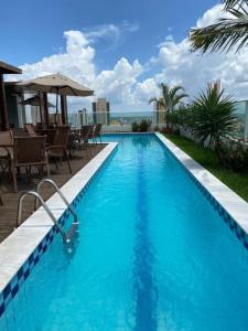 a large blue swimming pool with a view of the ocean at Apartamento em Nova Betânia - West Flat Mossoró in Mossoró