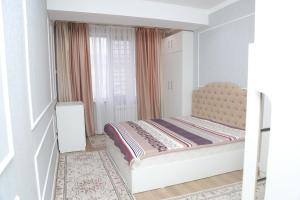 a small bedroom with a bed and a window at Апартаменты в центре Бишкека in Bishkek