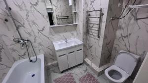 ein Badezimmer mit Waschbecken, Toilette und Dusche in der Unterkunft Апартаменты в центре Бишкека in Bischkek