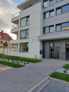 a white building with a driveway in front of it at Apartament Zamkowa Park Węgorzewo in Węgorzewo