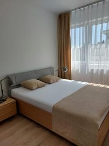 a bed in a bedroom with a large window at Apartament Zamkowa Park Węgorzewo in Węgorzewo