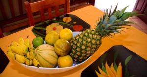 a bowl of fruit on a table with a pineapple at Maison de 2 chambres avec terrasse amenagee et wifi a Gros Morne in Gros-Morne