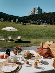 a table with food on it with a view of a mountain at Mountain Chalet Pra Ronch in Selva di Val Gardena