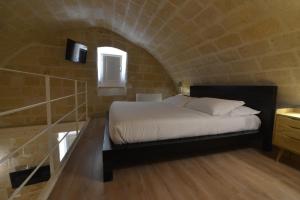 una camera con un letto in un muro di mattoni di Comera a Matera