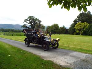 um carro à moda antiga a conduzir por uma estrada em Lismacue House em Bansha