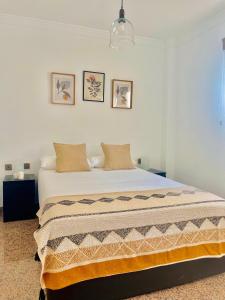 um quarto com uma grande cama branca e 2 almofadas em Encantadora Habitación Privada cerca del mar em Málaga