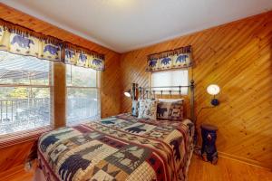 Schlafzimmer mit einem Bett mit Holzwänden und einem Fenster in der Unterkunft Mountain Memories in Gatlinburg