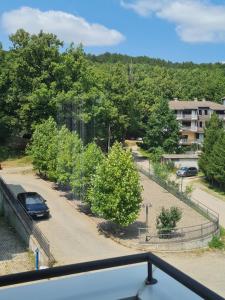 a car parked in a parking lot with trees at Apartman Natura in Vrnjačka Banja