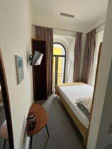 1 dormitorio con cama, mesa y ventana en Day Off Suite&Hostel, en Setúbal