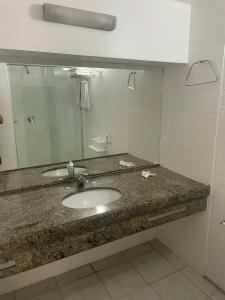 a bathroom with a sink and a mirror at Oasis Atlantico Fortaleza in Fortaleza