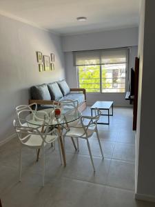 ein Wohnzimmer mit einem Sofa und einem Glastisch in der Unterkunft Departamentos por día - Bartolome.gralroca in General Roca