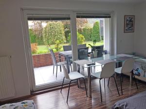 uma sala de jantar com uma mesa de vidro e cadeiras brancas em Apartment Dolce Vita em Celje