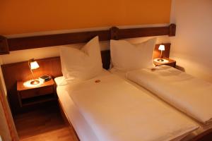 2 Betten in einem Zimmer mit zwei Lampen in der Unterkunft Pension Wolfgangsee in St. Wolfgang