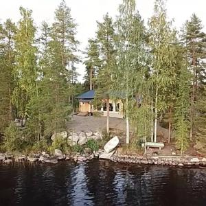 une maison sur la rive d'un lac avec un bateau dans l'établissement #casakivicco, à Leppävirta