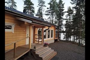 une cabane en rondins avec une véranda et une terrasse dans l'établissement #casakivicco, à Leppävirta