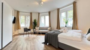 1 dormitorio con 1 cama y sala de estar con ventanas en Favorite Stays - Suite And More - 10 Min zur Messe, en Düsseldorf