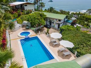 an aerial view of a house with a swimming pool and umbrellas at Hotel Villas de la Selva in Manuel Antonio