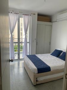 a bedroom with a bed and a door with a balcony at Aqualina Green Girardot in Girardot