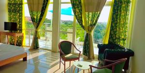 a living room with two chairs and a large window at Jozene House in Ngaparou