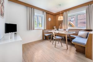 a living room and dining room with a table and a couch at App Garden Lanzmaria in Sorafurcia