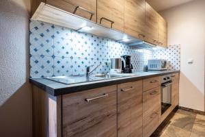 a kitchen with wooden cabinets and a sink at Alpenappart App Schwarzenstein in Cadipietra