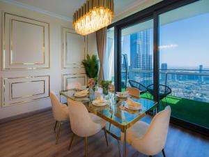 uma sala de jantar com mesa e cadeiras e uma grande janela em WORLD CLASS 3BR with full BURJ KHALIFA and FOUNTAIN VIEW em Dubai