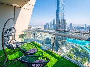 einen Balkon mit Stühlen und Stadtblick in der Unterkunft WORLD CLASS 3BR with full BURJ KHALIFA and FOUNTAIN VIEW in Dubai