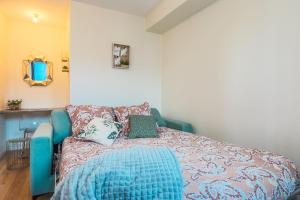 - une chambre avec un lit et un canapé bleu dans l'établissement Le Rabanesse Studio, à Clermont-Ferrand