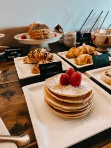 a table with a stack of pancakes and other desserts at Mountain Chalet Pra Ronch in Selva di Val Gardena