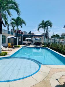 uma piscina com palmeiras e um edifício em Casa del mar em Tonsupa