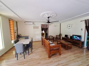 a living room with a table and a dining room at Rayyan Ashraf homestay in Kota Bharu