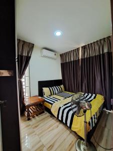 Rayyan Ashraf homestay في كوتا بْهارو: غرفة نوم فيها سريرين ومروحة