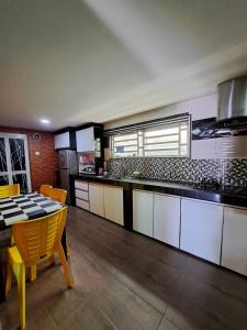 cocina grande con mesa y encimera en Rayyan Ashraf homestay en Kota Bharu