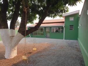 um baloiço pendurado numa árvore em frente a um edifício em Casa Verde em Limeira