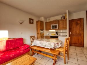a living room with a red couch and a table at Appartement Morillon 1100, 2 pièces, 6 personnes - FR-1-642-53 in Morillon