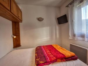 a bedroom with a bed with a colorful blanket on it at Appartement Morillon 1100, 2 pièces, 6 personnes - FR-1-642-53 in Morillon