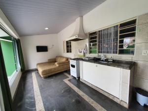 uma cozinha e sala de estar com um sofá em Casa Verde em Limeira