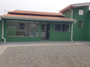 a green house with a large window in front of it at Casa Verde in Limeira