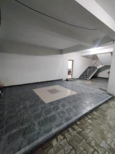 an empty room with a stone floor and stairs at Allamanda Abode in Chennai