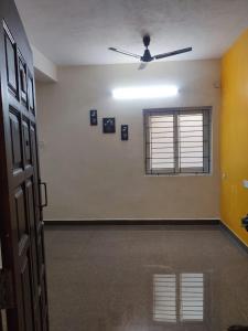 um quarto vazio com uma ventoinha de tecto e uma janela em Allamanda Abode em Chennai