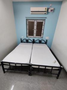 um quarto com uma cama num quarto azul em Allamanda Abode em Chennai