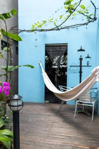 a hammock on the porch of a blue building at Guriri Recanto Paneágua cantinho de sossego in São Mateus