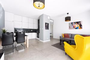 ein Wohnzimmer mit einem Tisch und gelben Stühlen in der Unterkunft Best Stay KRK in Krakau