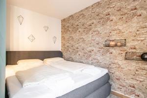 a bed in a room with a brick wall at Ein Stück Heimat mit Netflix in Bielefeld