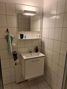 ein weißes Badezimmer mit einem Waschbecken und einem Spiegel in der Unterkunft Ein Stück Heimat mit Netflix in Bielefeld