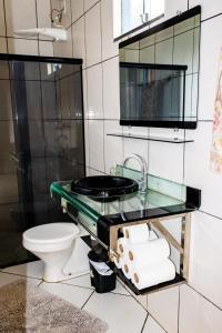 a bathroom with a sink and a toilet at Guriri Recanto Paneágua cantinho de sossego in São Mateus