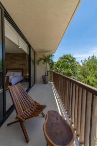 a balcony with a wooden bench and a table at D101 Beautiful Loft Steps From The Beach - Punta Cocos in Holbox Island