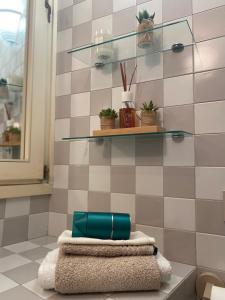 une salle de bains avec 3 serviettes et quelques plantes sur une étagère dans l'établissement Casa dolce Courmayeur cir0009, à Courmayeur