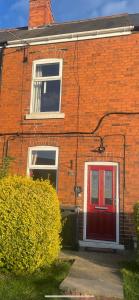a red brick house with a red door at Daniel’s Semi Rural Retreat in Clowne